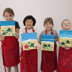 Studio portrait of young artists with beach paintings